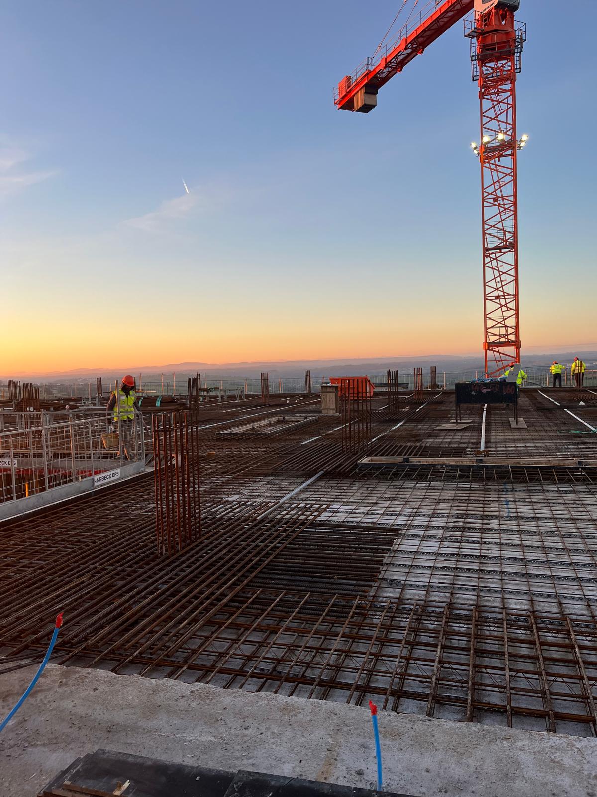 workers on the upper level using steel forms to get ready for concrete pouring